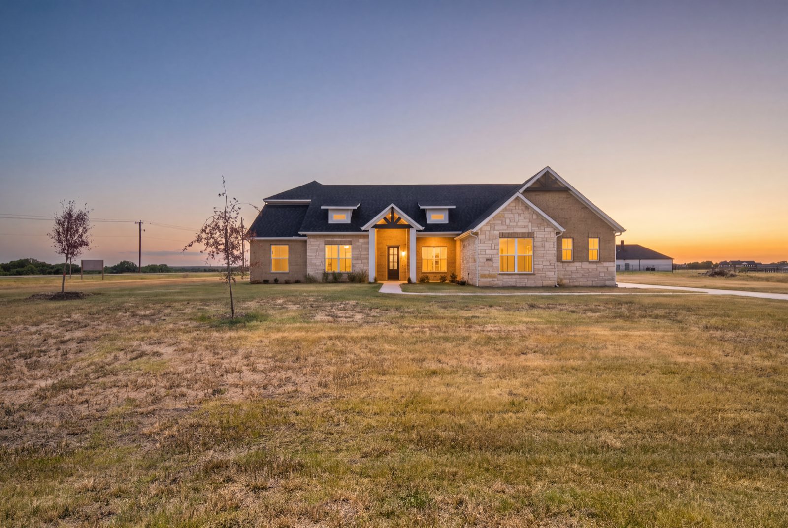 Single story home at twilight with glowing windows, Ellis County